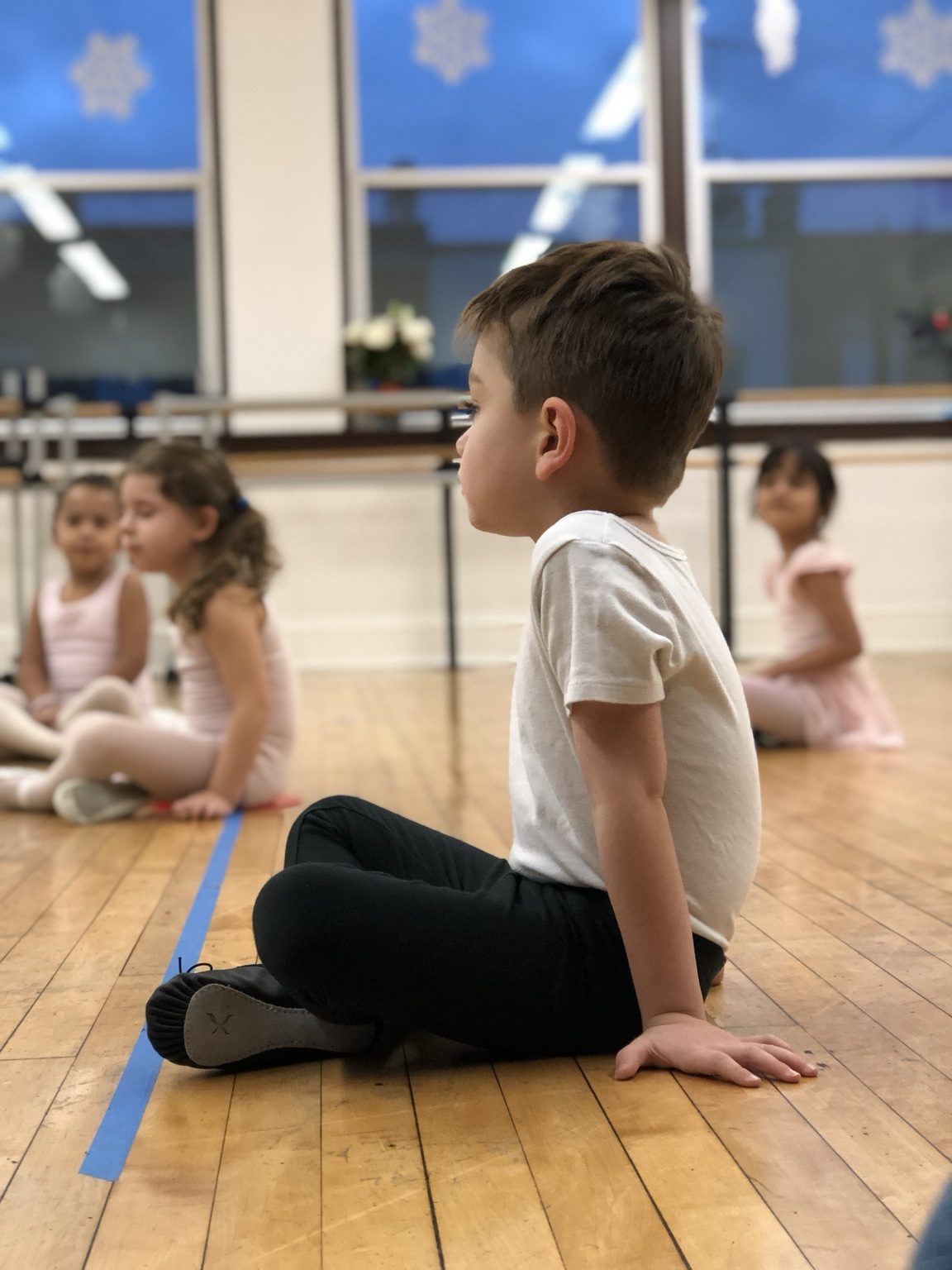 A young dancer sitting in his first ballet studio