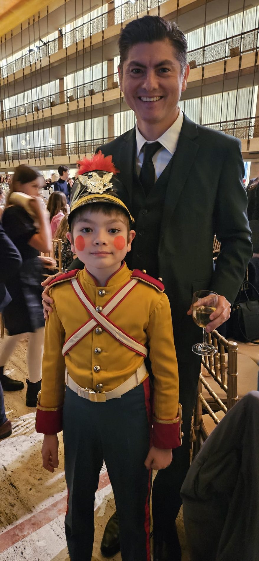 Young performer dressed for a ballet production with a parent